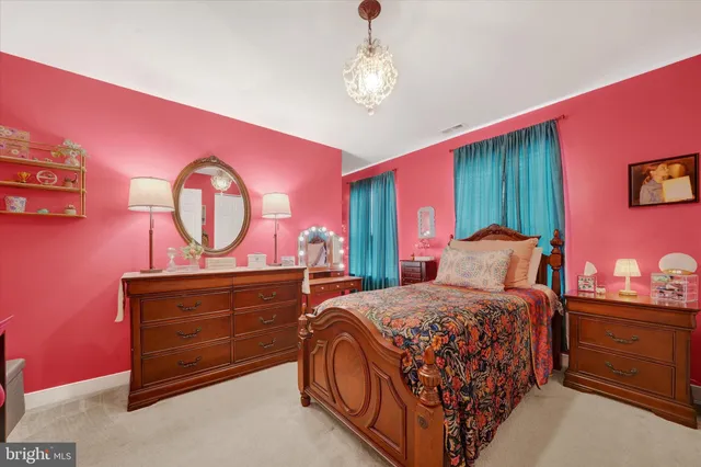 a bedroom with a bed and dresser with mirror