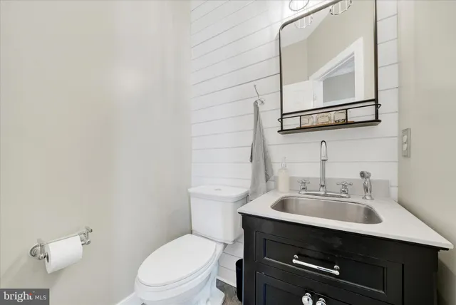 a bathroom with a sink a toilet and mirror