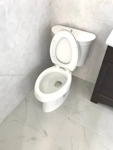 a bathroom with a toilet and a mirror
