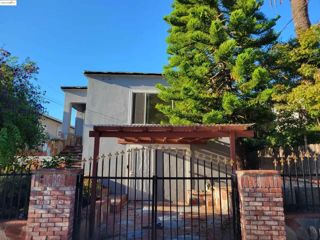 a view of a brick house with a small yard and plants