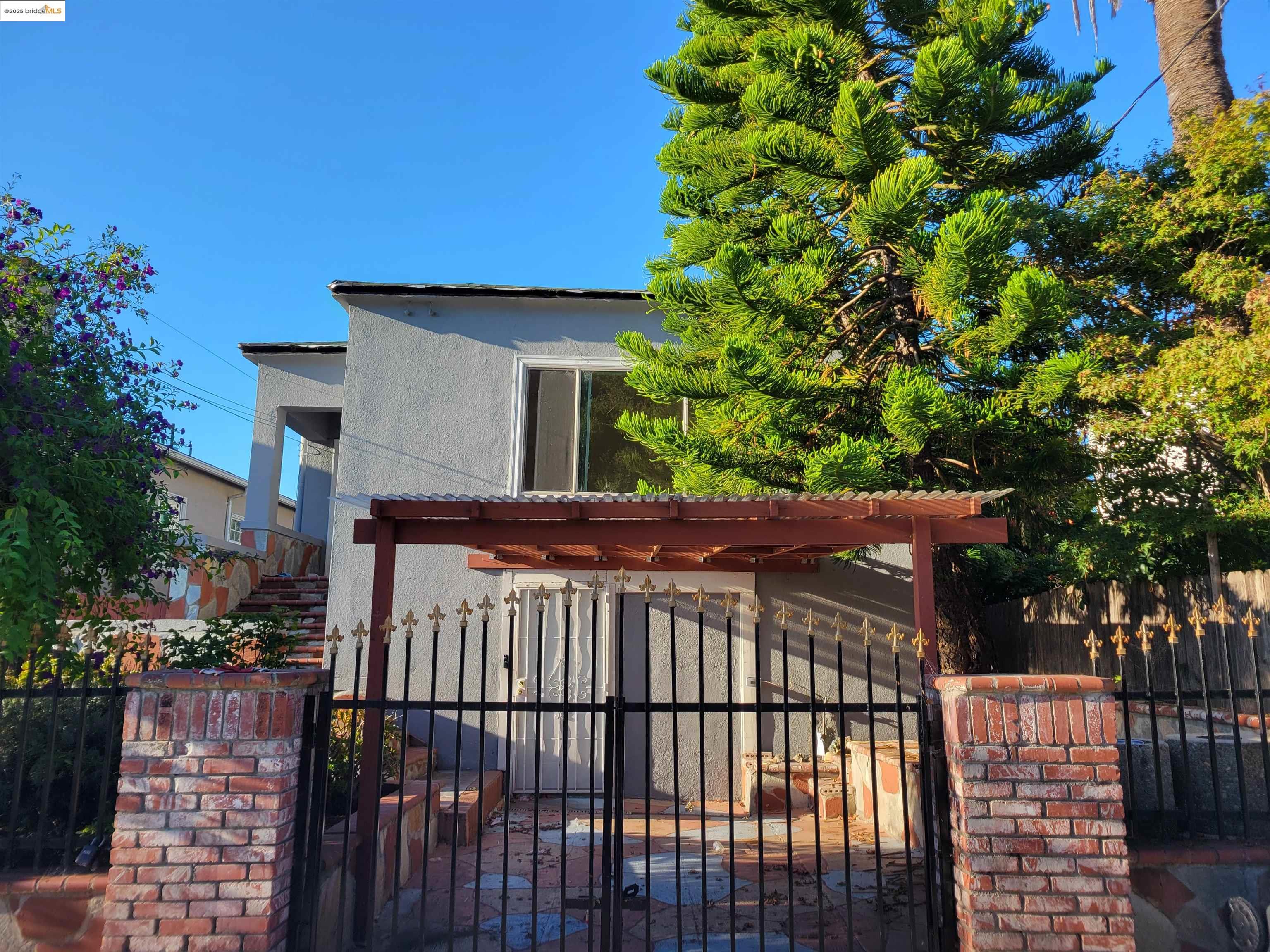 a view of a brick house with a small yard and plants