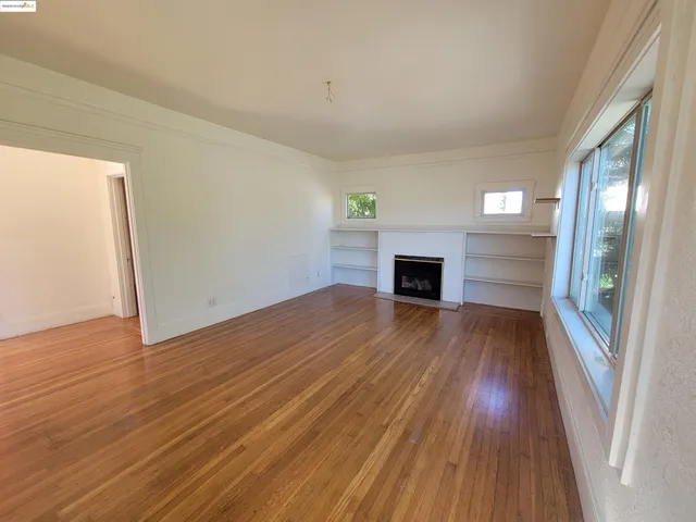 a view of a room with wooden floor and a potted plant