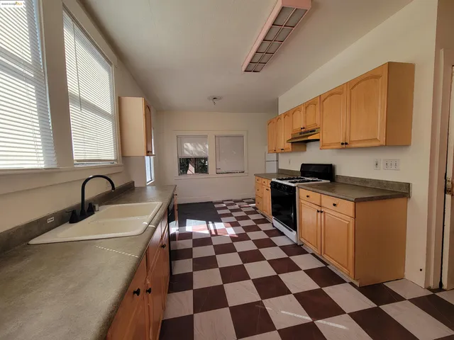 a kitchen with a checkered floor and white cabinets