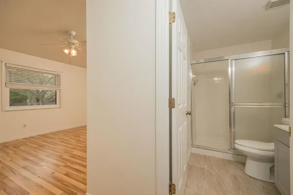 an empty room with a window and a ceiling fan