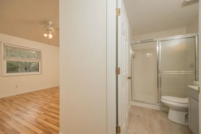 an empty room with a window and a ceiling fan