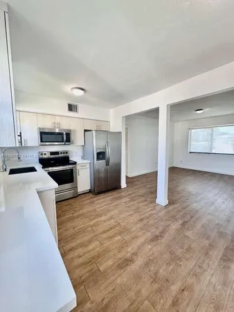 a view of kitchen with refrigerator sink and stove