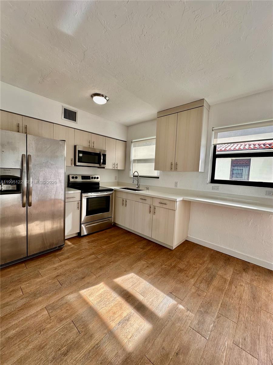 4203 Southwest 15th Street, Unit 2 Miami, FL 33145 - Photo 8 of 17 a large kitchen with cabinets and stainless steel appliances