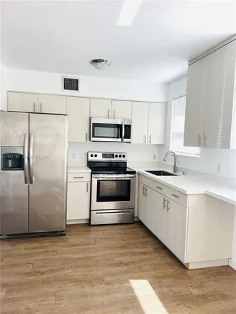 a kitchen with a refrigerator sink and microwave