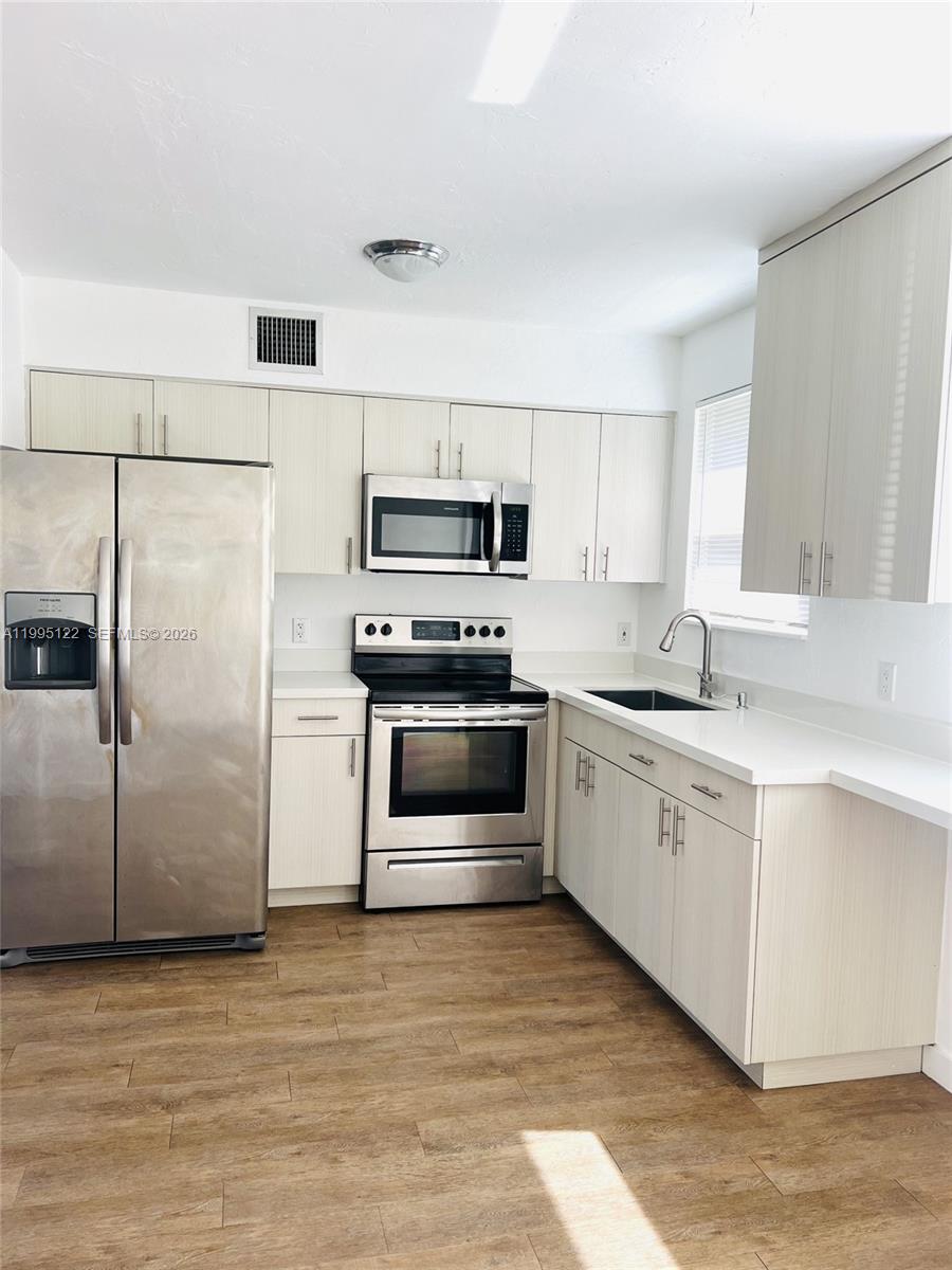 4203 Southwest 15th Street, Unit 2 Miami, FL 33145 - Photo 9 of 17 a kitchen with a refrigerator sink and microwave