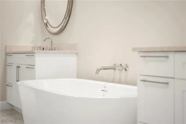 a bathroom with a tub sink and mirror