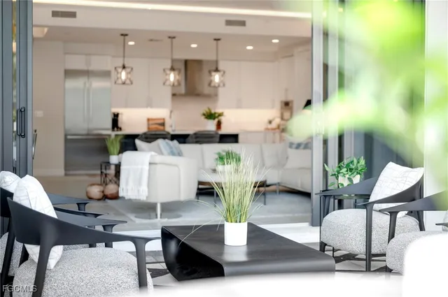 a view of a patio with table and chairs potted plants and palm tree