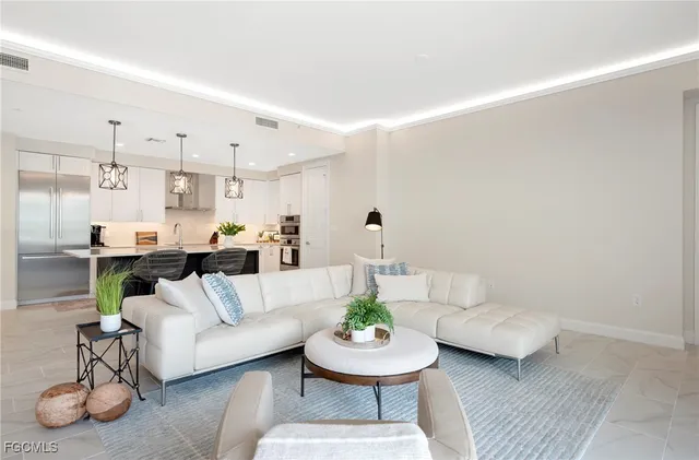 a living room with furniture and a dining table with kitchen view