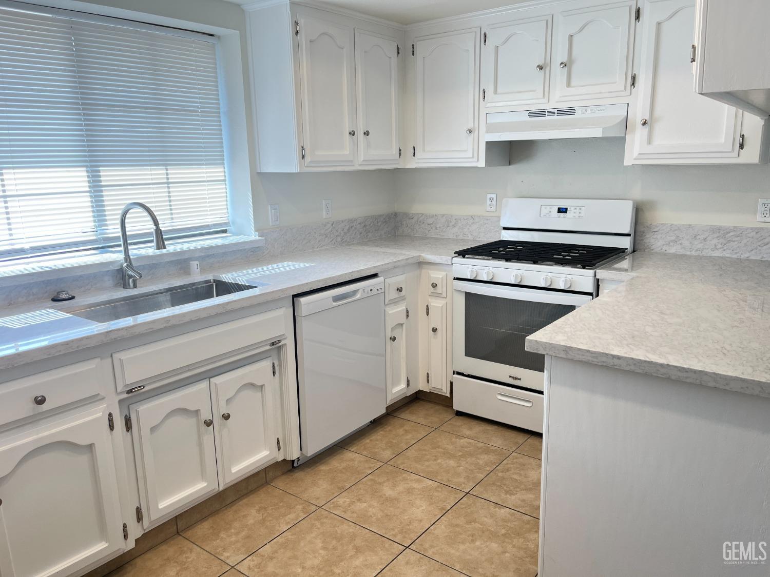 Undisclosed Address Bakersfield, CA 93311 - Photo 6 of 12 a kitchen with white cabinets and appliances