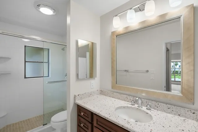 a bathroom with a granite countertop sink and a mirror