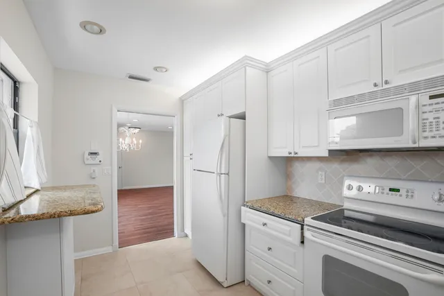 a kitchen with a refrigerator sink and cabinets