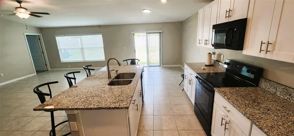 a kitchen with granite countertop a sink and a stove top oven