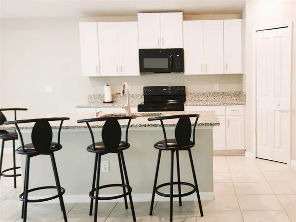a kitchen with a table chairs and appliances