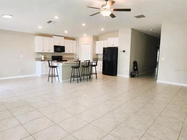 a view of kitchen with stainless steel appliances kitchen island granite countertop lots of counter top space and cabinets
