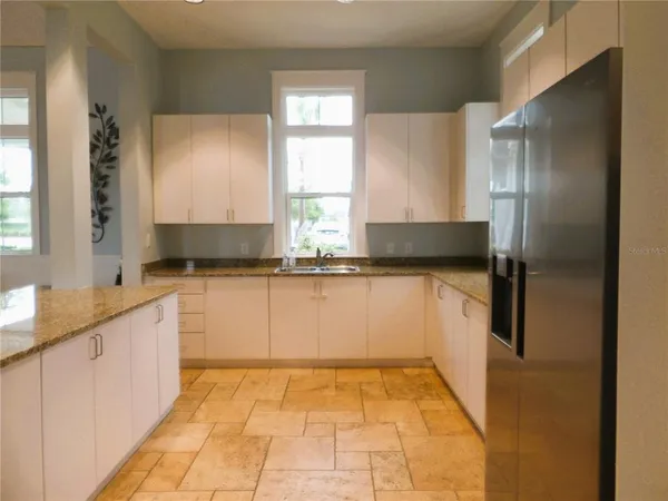 a kitchen with granite countertop a refrigerator and a sink