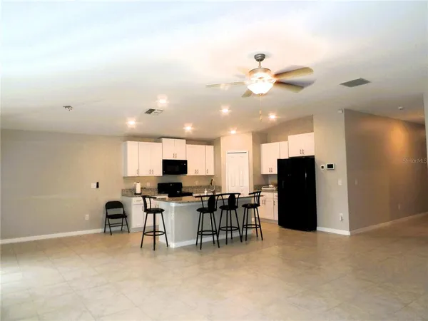 a view of kitchen with furniture and a ceiling fan