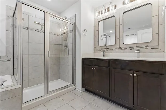 a bathroom with a double vanity sink mirror and shower
