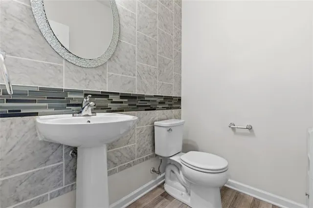 a bathroom with a sink a toilet and a mirror