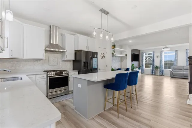 a kitchen with stainless steel appliances a stove center island refrigerator and cabinets