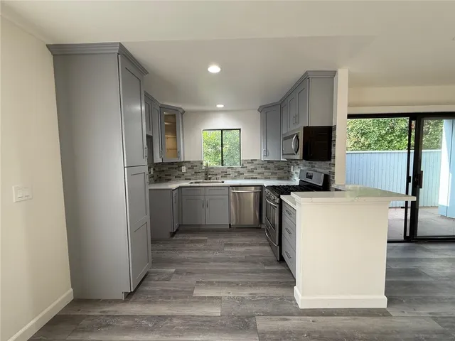 a kitchen with a sink cabinets stainless steel appliances and a window