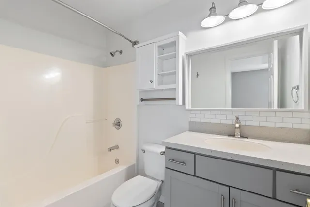 a bathroom with a sink toilet vanity and shower