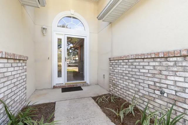 a view of a hallway with wooden floor and a black white wall
