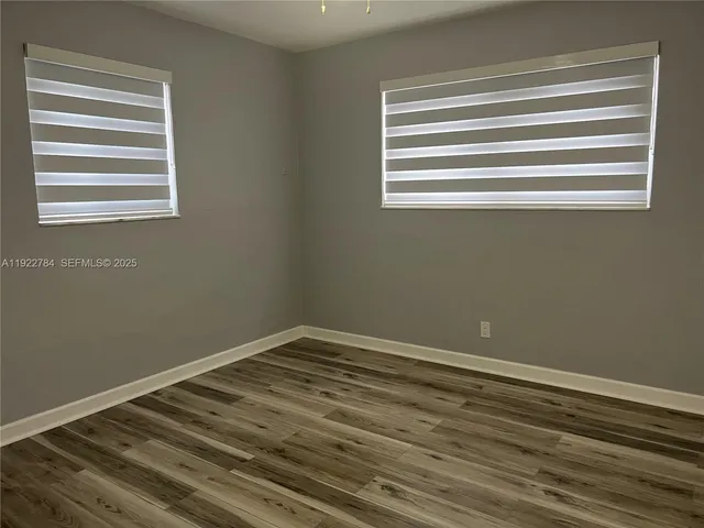 a view of a room with wooden floor and a window