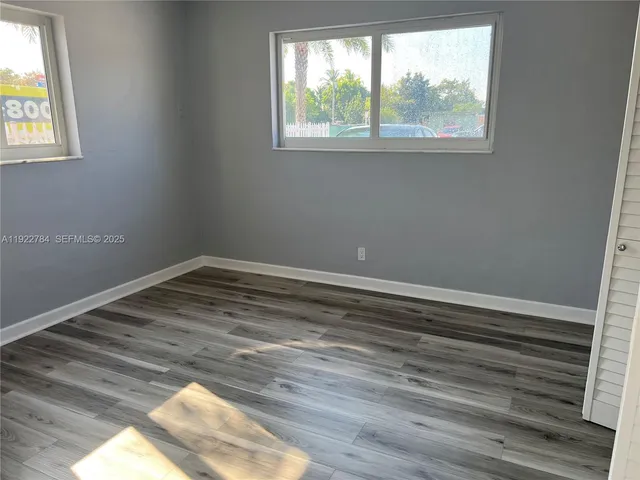 a view of a room with wooden floor and windows