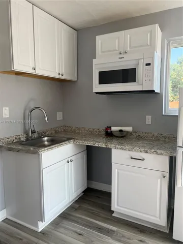 a kitchen with stainless steel appliances granite countertop a sink and a microwave