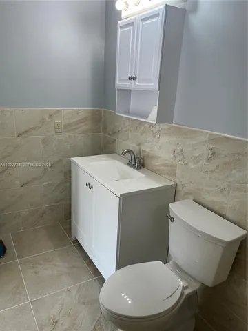 a white toilet sitting next to a bathroom sink