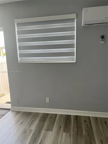 a view of a room with wooden floor and a window