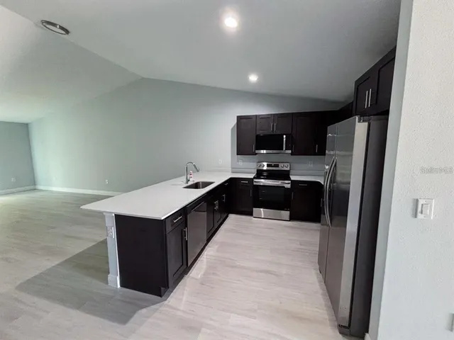 a kitchen with stainless steel appliances a refrigerator stove microwave and sink