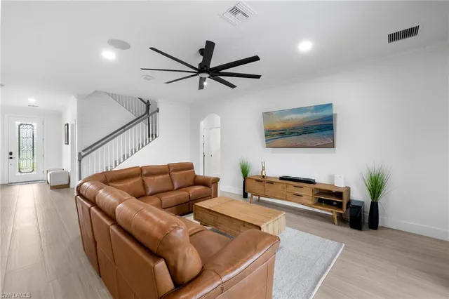 a living room with furniture and a wooden floor