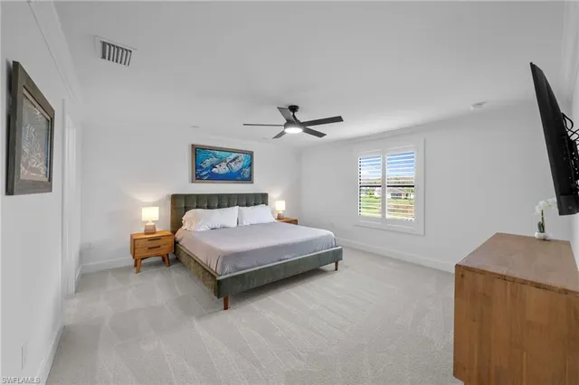 a spacious bedroom with a bed and a flat screen tv