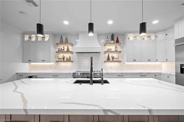 a living room with kitchen island furniture and a chandelier