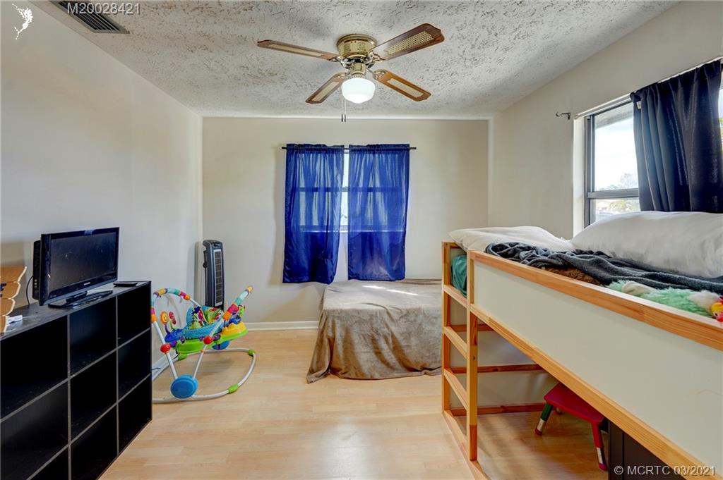 4918 Southeast Salvatori Road Stuart, FL 34997 - Photo 13 of 37 a bed room with a bed and a window
