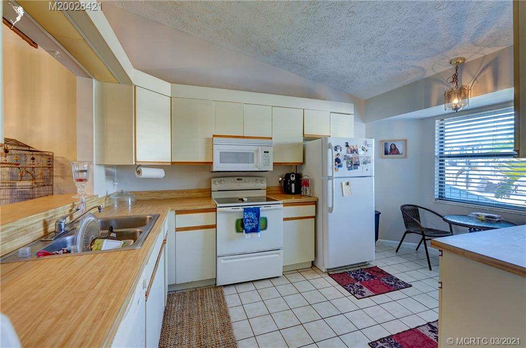 4918 Southeast Salvatori Road Stuart, FL 34997 - Photo 18 of 37 a kitchen with a refrigerator and a stove top oven