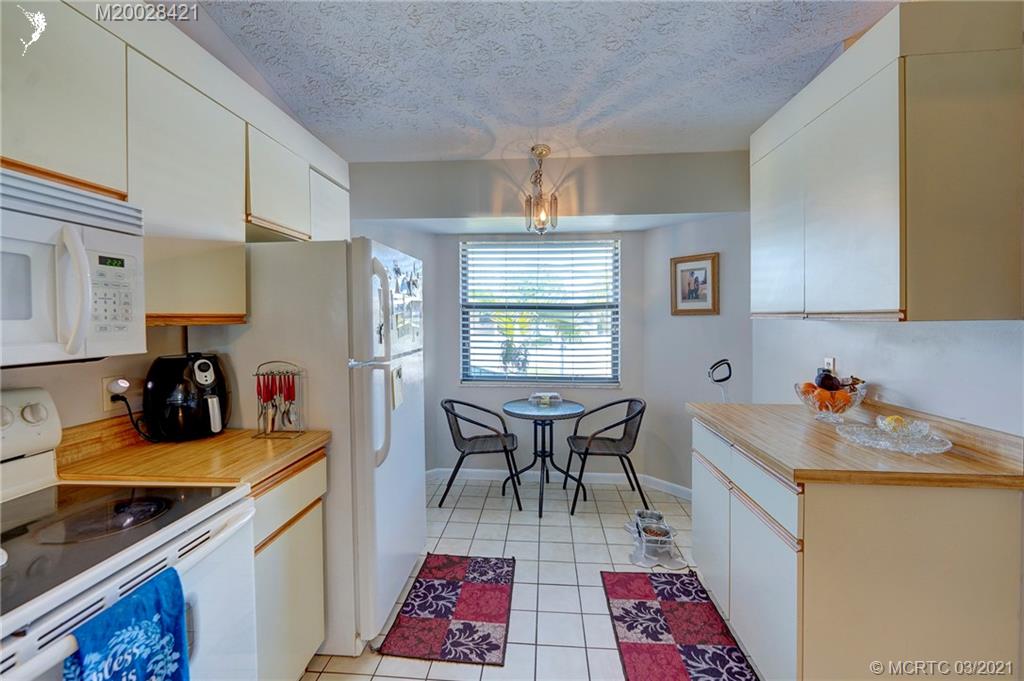 4918 Southeast Salvatori Road Stuart, FL 34997 - Photo 19 of 37 a kitchen with a sink a stove a refrigerator and cabinets