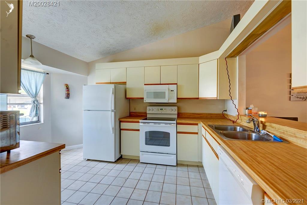 4918 Southeast Salvatori Road Stuart, FL 34997 - Photo 2 of 37 a kitchen with a sink stove and refrigerator