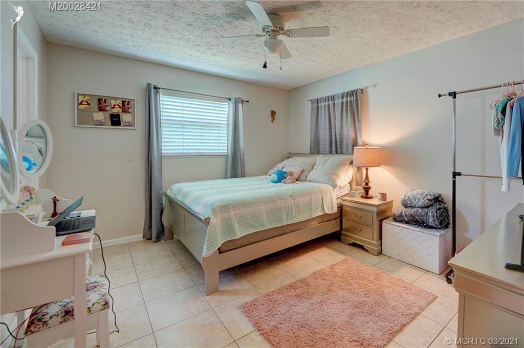 4918 Southeast Salvatori Road Stuart, FL 34997 - Photo 26 of 37 a bedroom with a bed and a couch