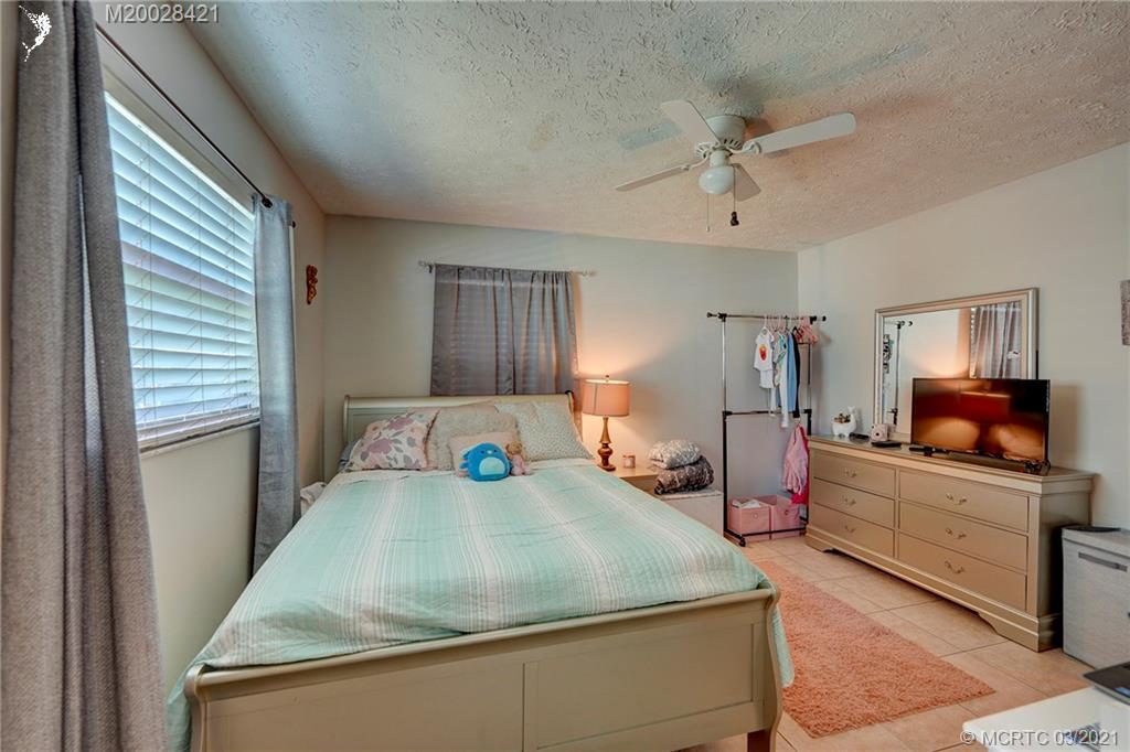 4918 Southeast Salvatori Road Stuart, FL 34997 - Photo 28 of 37 a bedroom with a bed and a large mirror