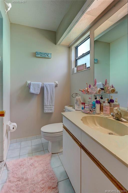 4918 Southeast Salvatori Road Stuart, FL 34997 - Photo 29 of 37 a bathroom with a sink a toilet and mirror
