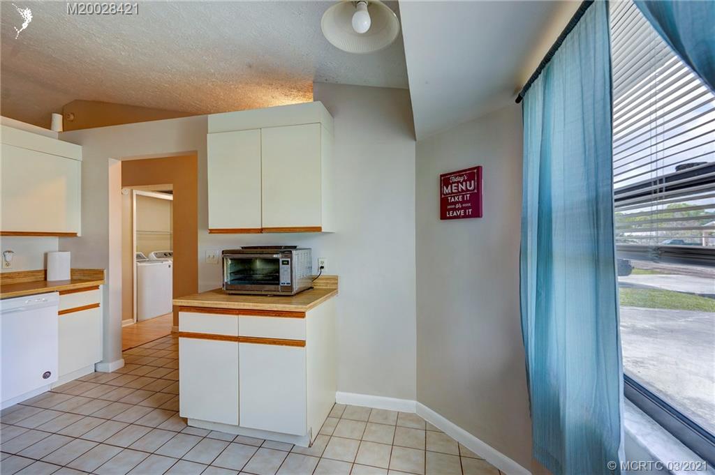 4918 Southeast Salvatori Road Stuart, FL 34997 - Photo 3 of 37 a kitchen with white cabinets and white appliances