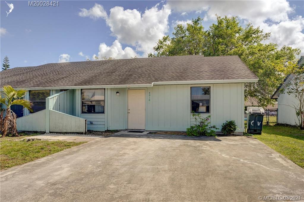 4918 Southeast Salvatori Road Stuart, FL 34997 - Photo 31 of 37 a front view of house with yard and trees in the background