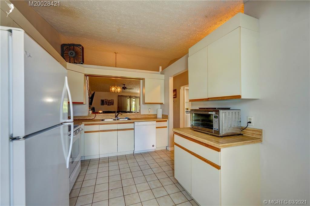 4918 Southeast Salvatori Road Stuart, FL 34997 - Photo 4 of 37 a kitchen with stainless steel appliances a stove refrigerator and a sink