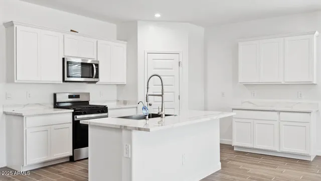 a kitchen with stainless steel appliances granite countertop a sink stove microwave and cabinets